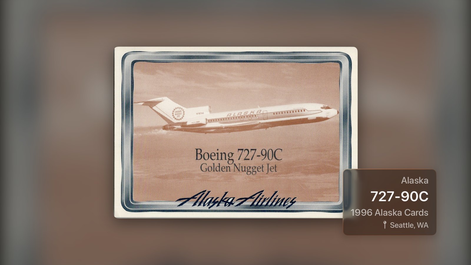 PTC Binder Theater en Apple TV, con una tarjeta Boeing 727-90C Golden Nugget Jet de Alaska Airlines de 1996 llenando la pantalla, la misma tarjeta desenfocada de fondo y sus datos en la esquina.